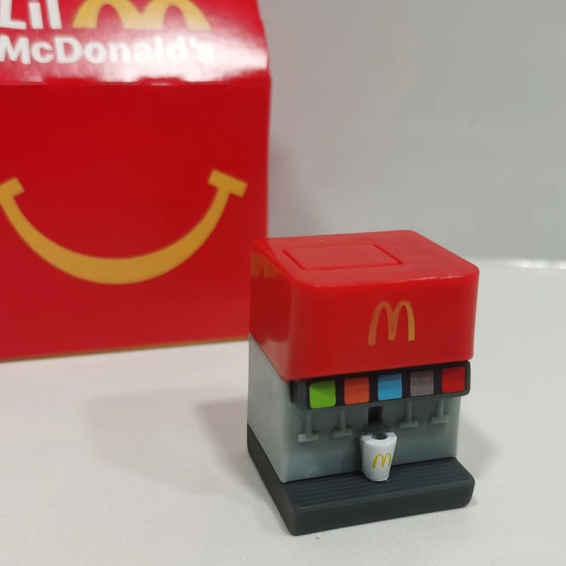 ألعاب بيت اللعب من ماكدونالدز، تشمل مجسمات مكونات المطعم، صناديق وجبات، ماكينات الطلب، وقبعات للأطفال، نموذج لعب واقعي