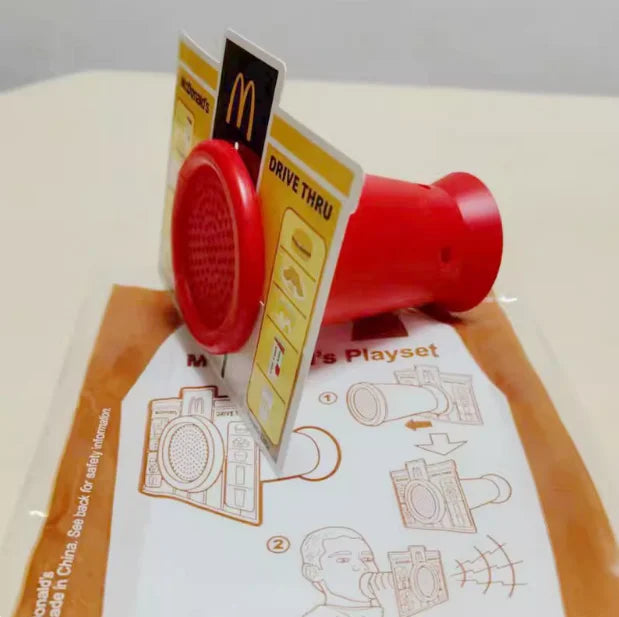 ألعاب بيت اللعب من ماكدونالدز، تشمل مجسمات مكونات المطعم، صناديق وجبات، ماكينات الطلب، وقبعات للأطفال، نموذج لعب واقعي