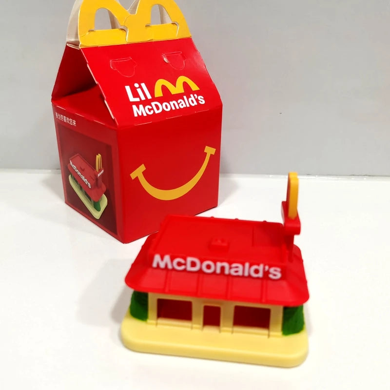 ألعاب بيت اللعب من ماكدونالدز، تشمل مجسمات مكونات المطعم، صناديق وجبات، ماكينات الطلب، وقبعات للأطفال، نموذج لعب واقعي