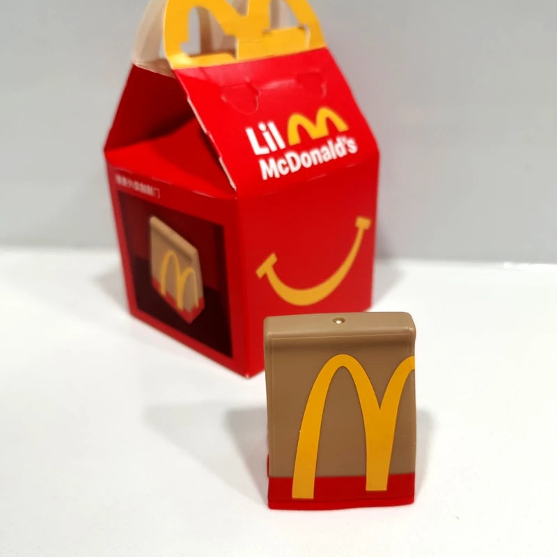ألعاب بيت اللعب من ماكدونالدز، تشمل مجسمات مكونات المطعم، صناديق وجبات، ماكينات الطلب، وقبعات للأطفال، نموذج لعب واقعي