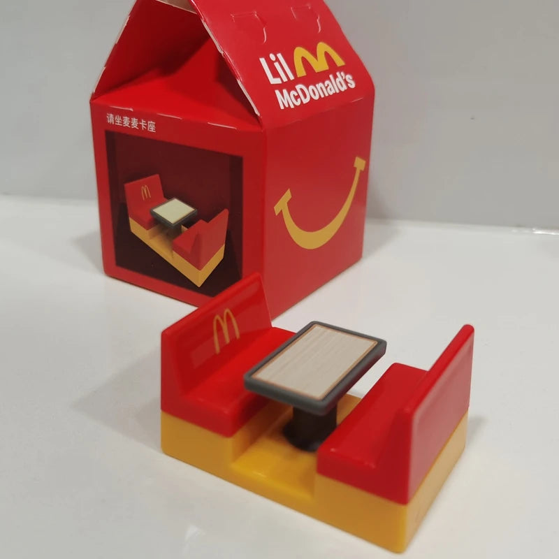 ألعاب بيت اللعب من ماكدونالدز، تشمل مجسمات مكونات المطعم، صناديق وجبات، ماكينات الطلب، وقبعات للأطفال، نموذج لعب واقعي