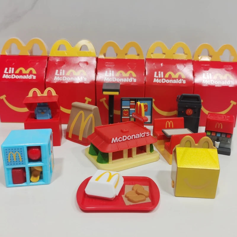 ألعاب بيت اللعب من ماكدونالدز، تشمل مجسمات مكونات المطعم، صناديق وجبات، ماكينات الطلب، وقبعات للأطفال، نموذج لعب واقعي