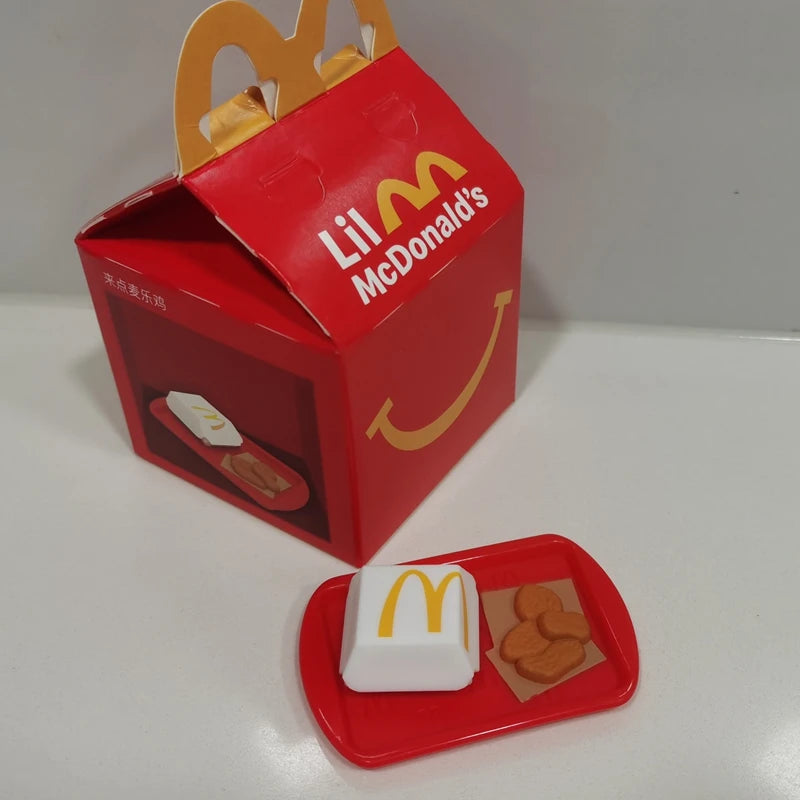 ألعاب بيت اللعب من ماكدونالدز، تشمل مجسمات مكونات المطعم، صناديق وجبات، ماكينات الطلب، وقبعات للأطفال، نموذج لعب واقعي
