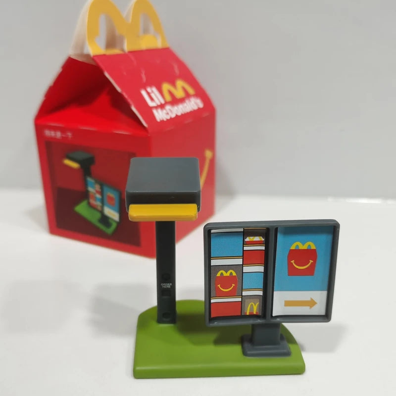 ألعاب بيت اللعب من ماكدونالدز، تشمل مجسمات مكونات المطعم، صناديق وجبات، ماكينات الطلب، وقبعات للأطفال، نموذج لعب واقعي